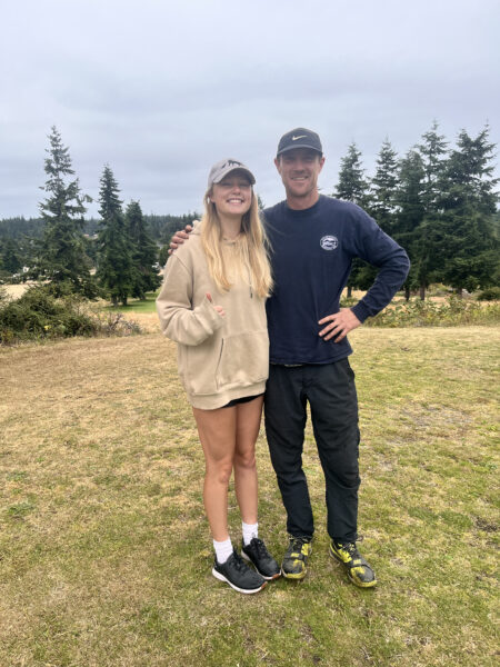 Maisie Walker stands next to one of her capstone supervisors at the golf course.
