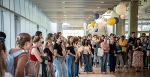 Students stand in a circle in the Fishery Sciences lobby listening to a presentation.