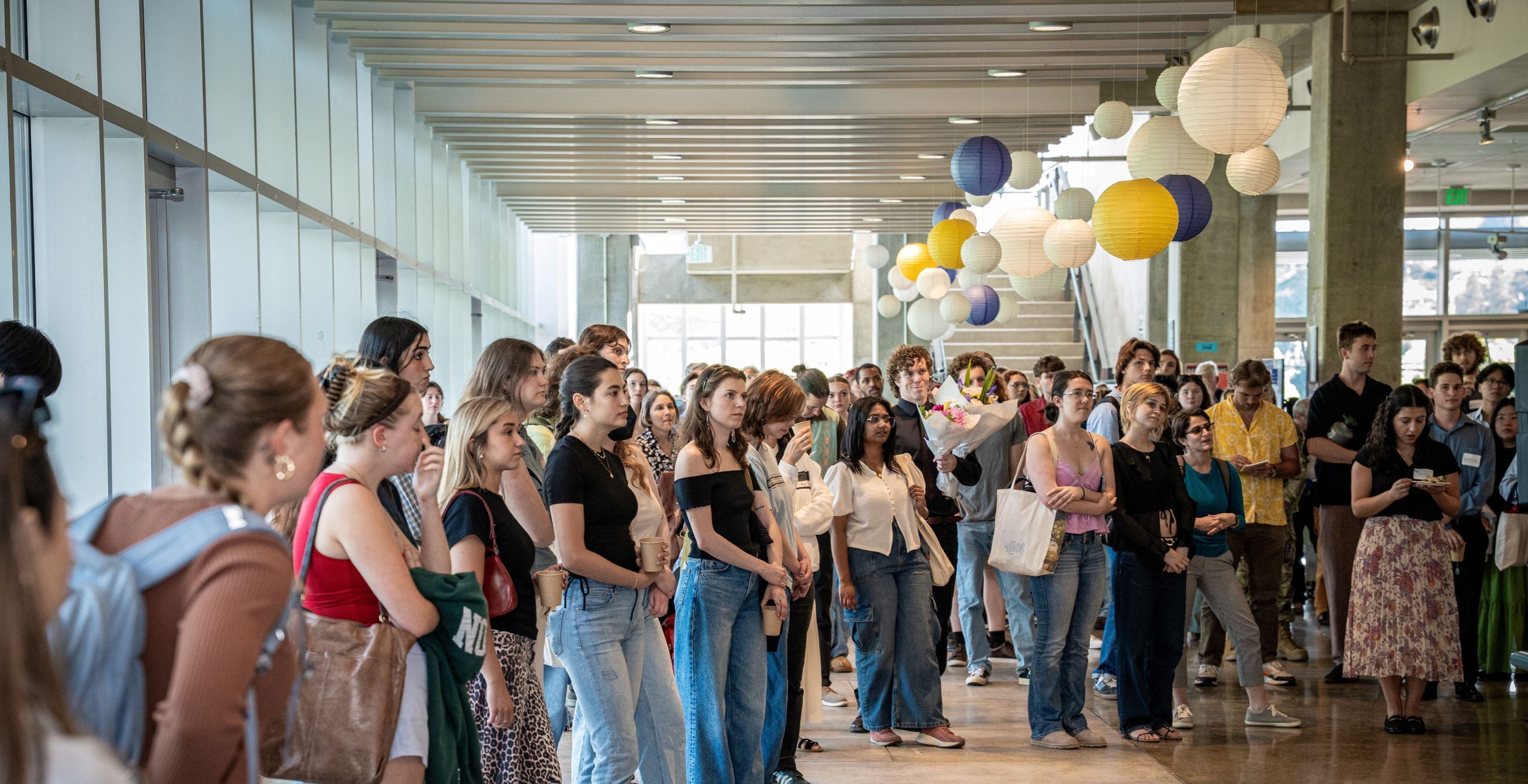Students stand in a circle in the Fishery Sciences lobby listening to a presentation.