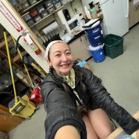 Mia Nelson takes a self while sitting at a desk.